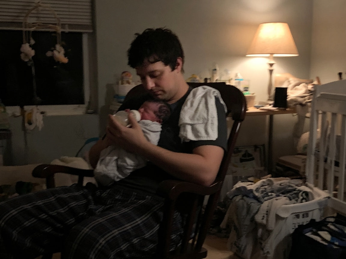 Father doing night bottle feed with newborn